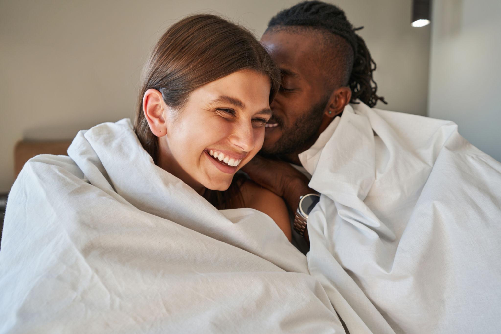 Glückliches Paar unterhält sich im Bett